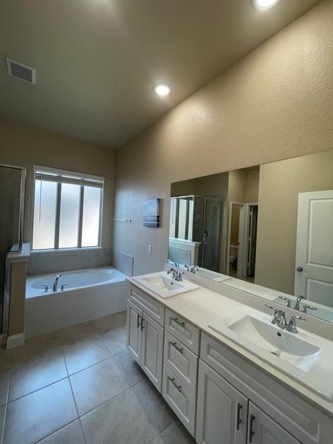 569 Spruce Trail Forney, TX 75126 - Photo 10 of 22 Bathroom featuring double vanity, a garden tub, a stall shower, light tile patterned floors, and recessed lighting