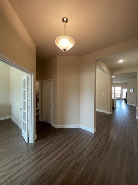 569 Spruce Trail Forney, TX 75126 - Photo 19 of 22 Spare room featuring baseboards and dark wood-type flooring