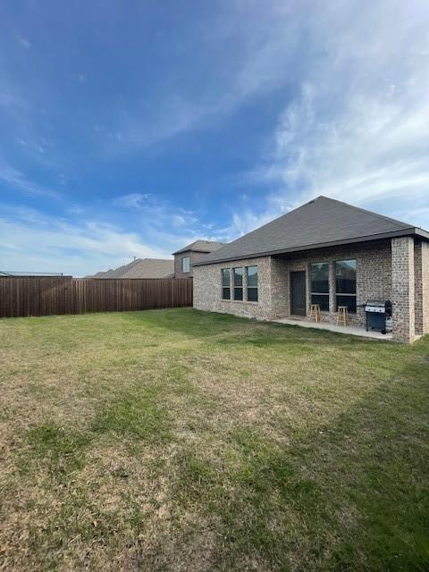 569 Spruce Trail Forney, TX 75126 - Photo 2 of 22 Back of house with a patio, a fenced backyard, and brick siding