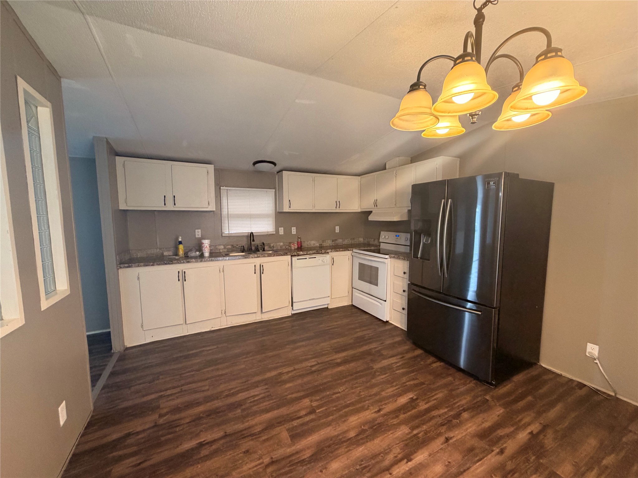 2021 North Battlebell Road, Unit 40 Highlands, TX 77562 - Photo 2 of 19 a kitchen with stainless steel appliances granite countertop a refrigerator a sink dishwasher a stove and white cabinets with wooden floor