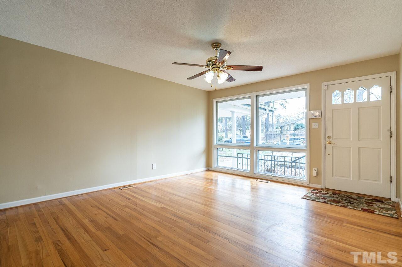 211 Quail Drive Raleigh, NC 27604 - Photo 5 of 28 a view of an empty room with wooden floor and a window