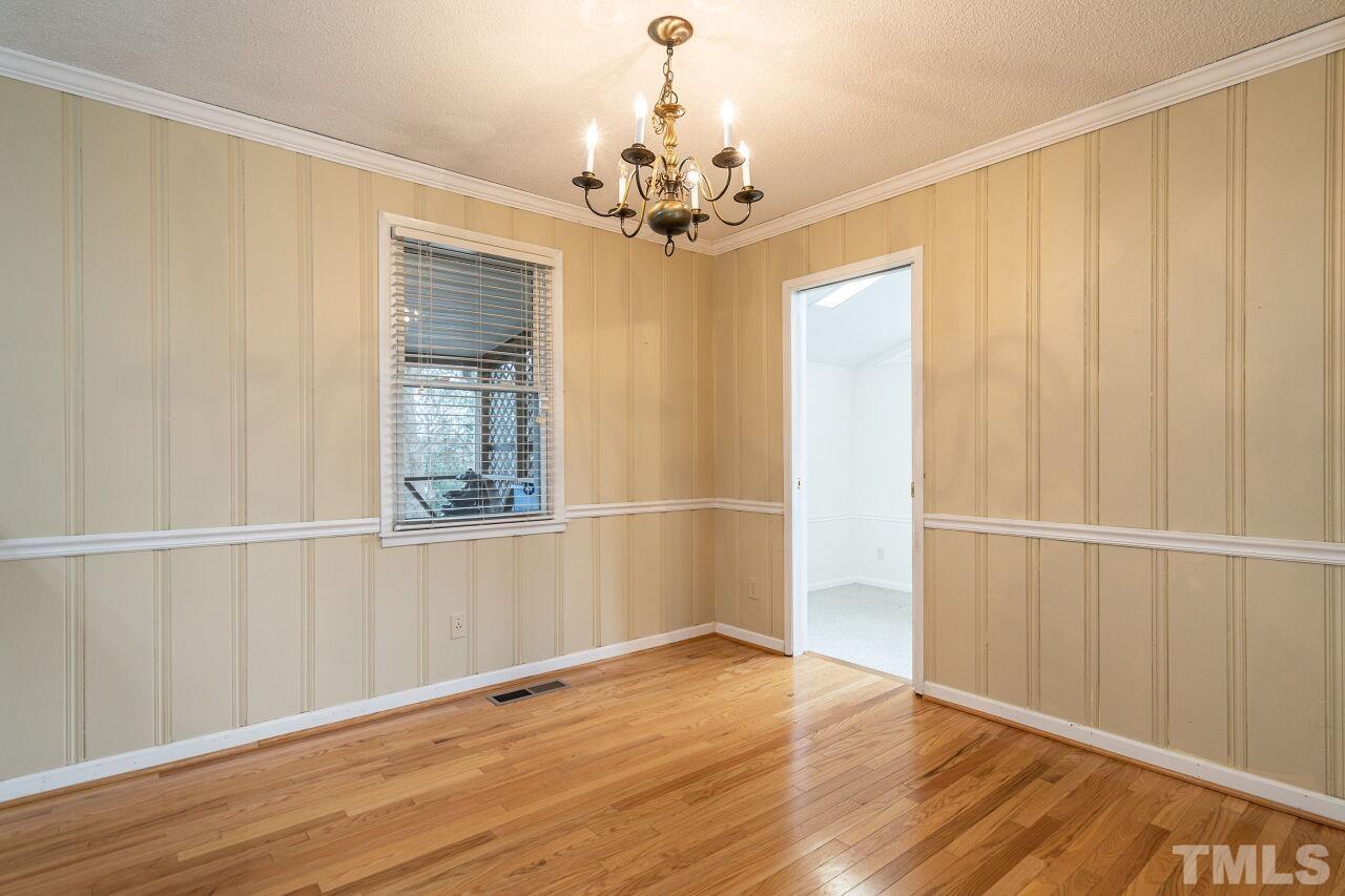211 Quail Drive Raleigh, NC 27604 - Photo 8 of 28 a view of an empty room with wooden floor and a window