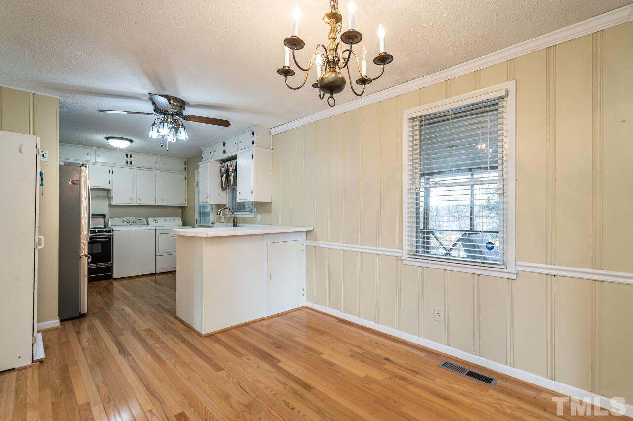 211 Quail Drive Raleigh, NC 27604 - Photo 9 of 28 a view of a kitchen with a sink wooden floor and a window