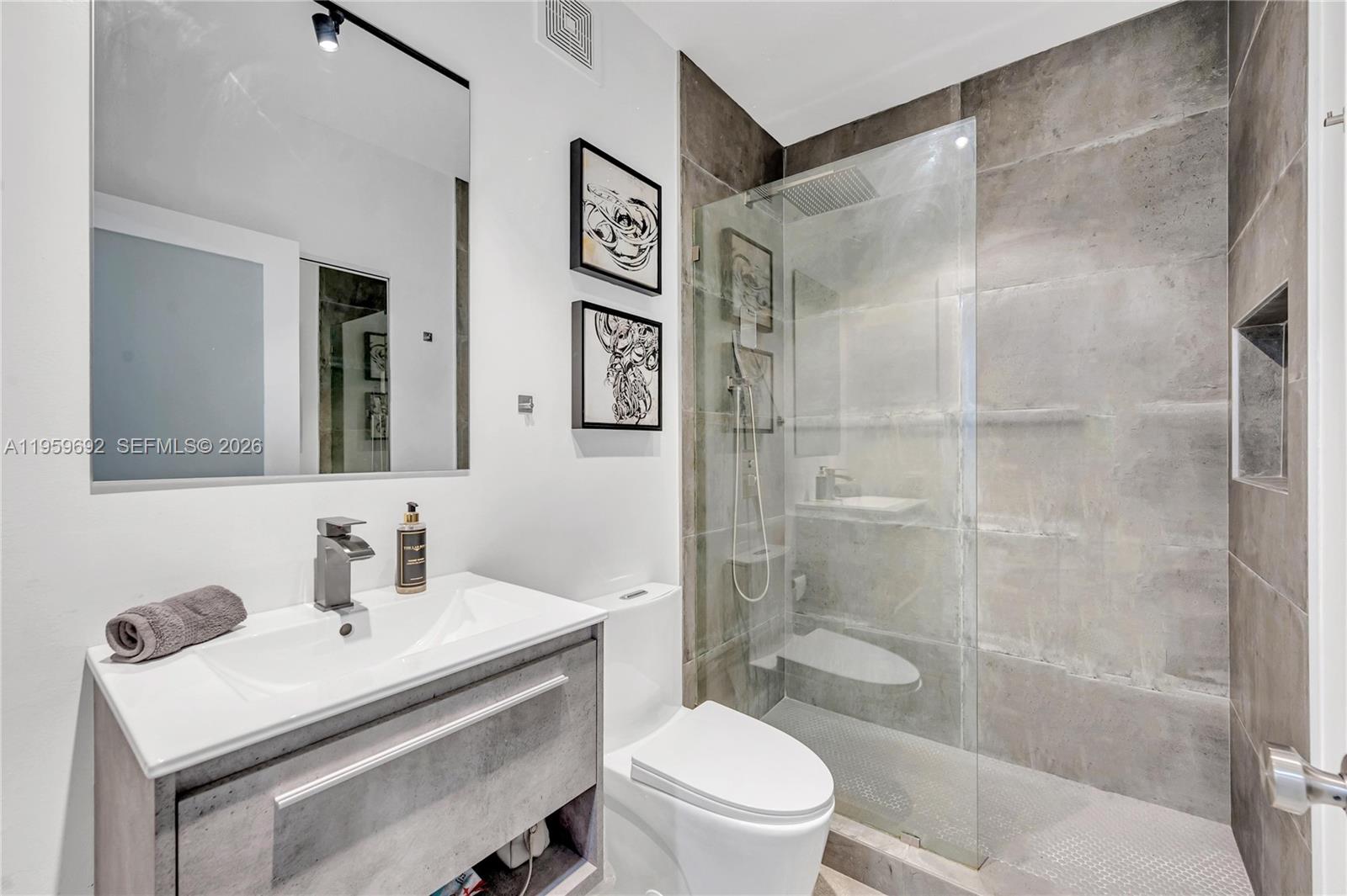 540 Brickell Key Drive, Unit 409 Miami, FL 33131 - Photo 16 of 20 a bathroom with a sink toilet vanity and shower