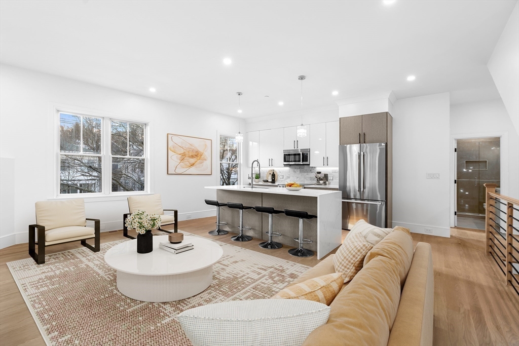 a living room with furniture and kitchen view