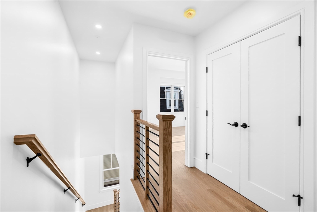 143 Tremont Street, Unit A Boston, MA 02135 - Photo 11 of 28 a view of a hallway with wooden floor and staircase