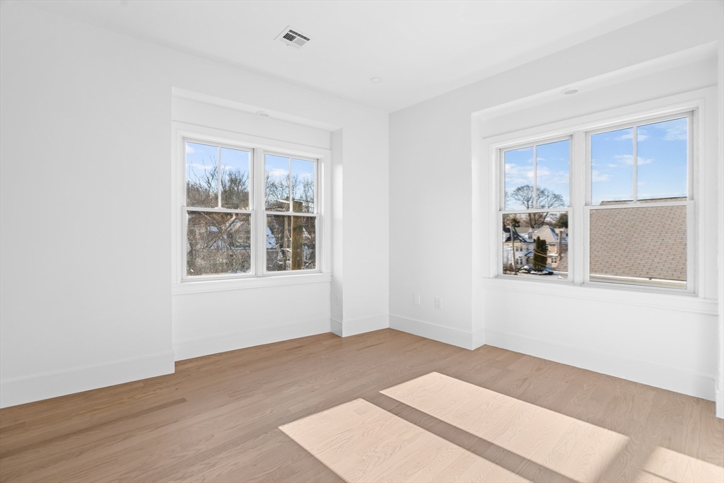 143 Tremont Street, Unit A Boston, MA 02135 - Photo 16 of 28 a view of a big room with wooden floor and windows