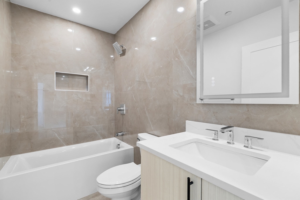143 Tremont Street, Unit A Boston, MA 02135 - Photo 18 of 28 a bathroom with a sink a toilet and shower