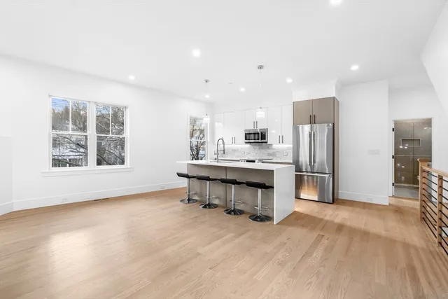 a kitchen with stainless steel appliances kitchen island hardwood floor sink and stove