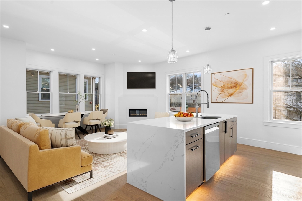143 Tremont Street, Unit A Boston, MA 02135 - Photo 3 of 28 a living room with stainless steel appliances kitchen island granite countertop a stove and a wooden floors