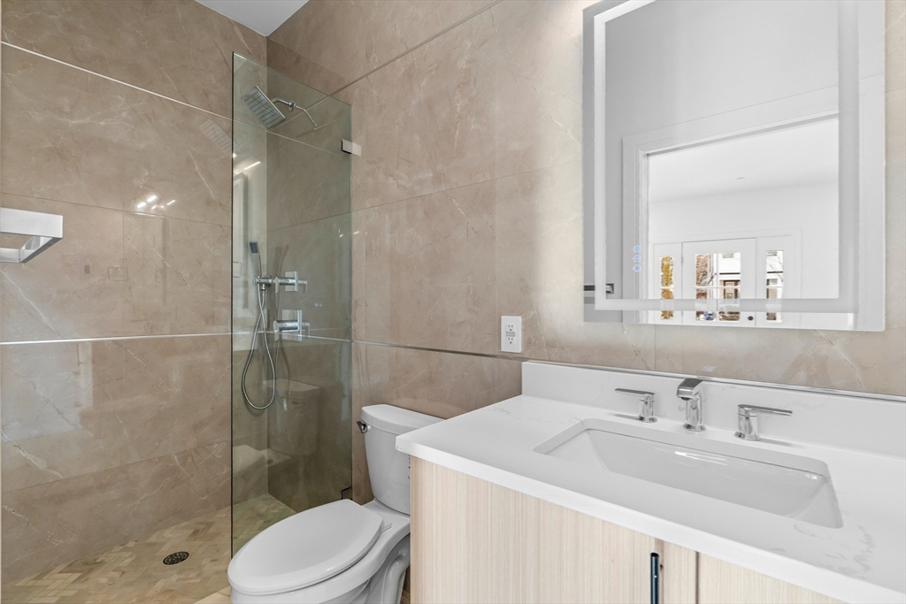 143 Tremont Street, Unit A Boston, MA 02135 - Photo 10 of 28 a bathroom with a sink toilet and shower