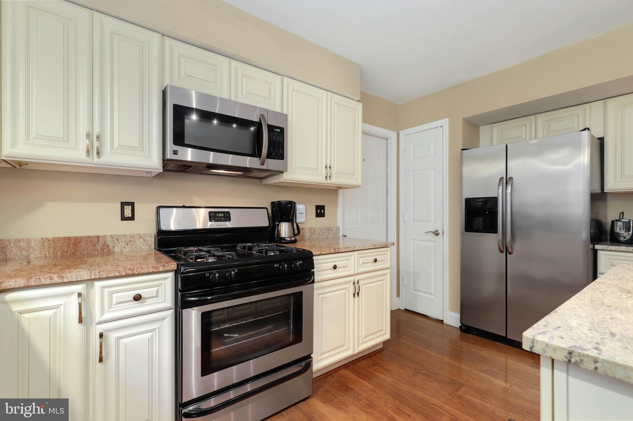 9211 Sandy Creek Road Fort Washington, MD 20744 - Photo 16 of 30 a kitchen with stainless steel appliances granite countertop a stove a refrigerator and a microwave