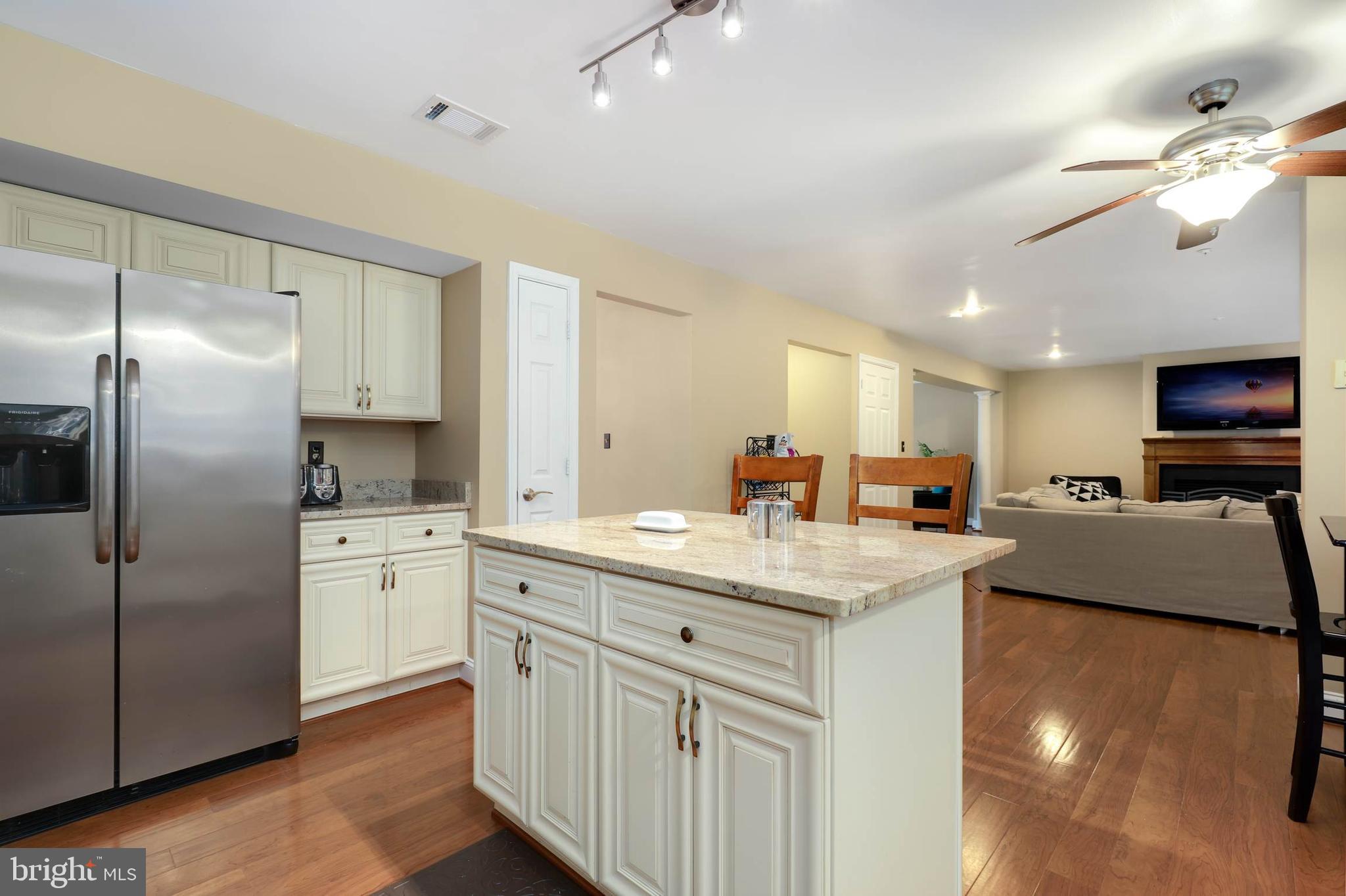 9211 Sandy Creek Road Fort Washington, MD 20744 - Photo 17 of 30 a kitchen with stainless steel appliances granite countertop a refrigerator a sink dishwasher a oven with white cabinets and wooden floor