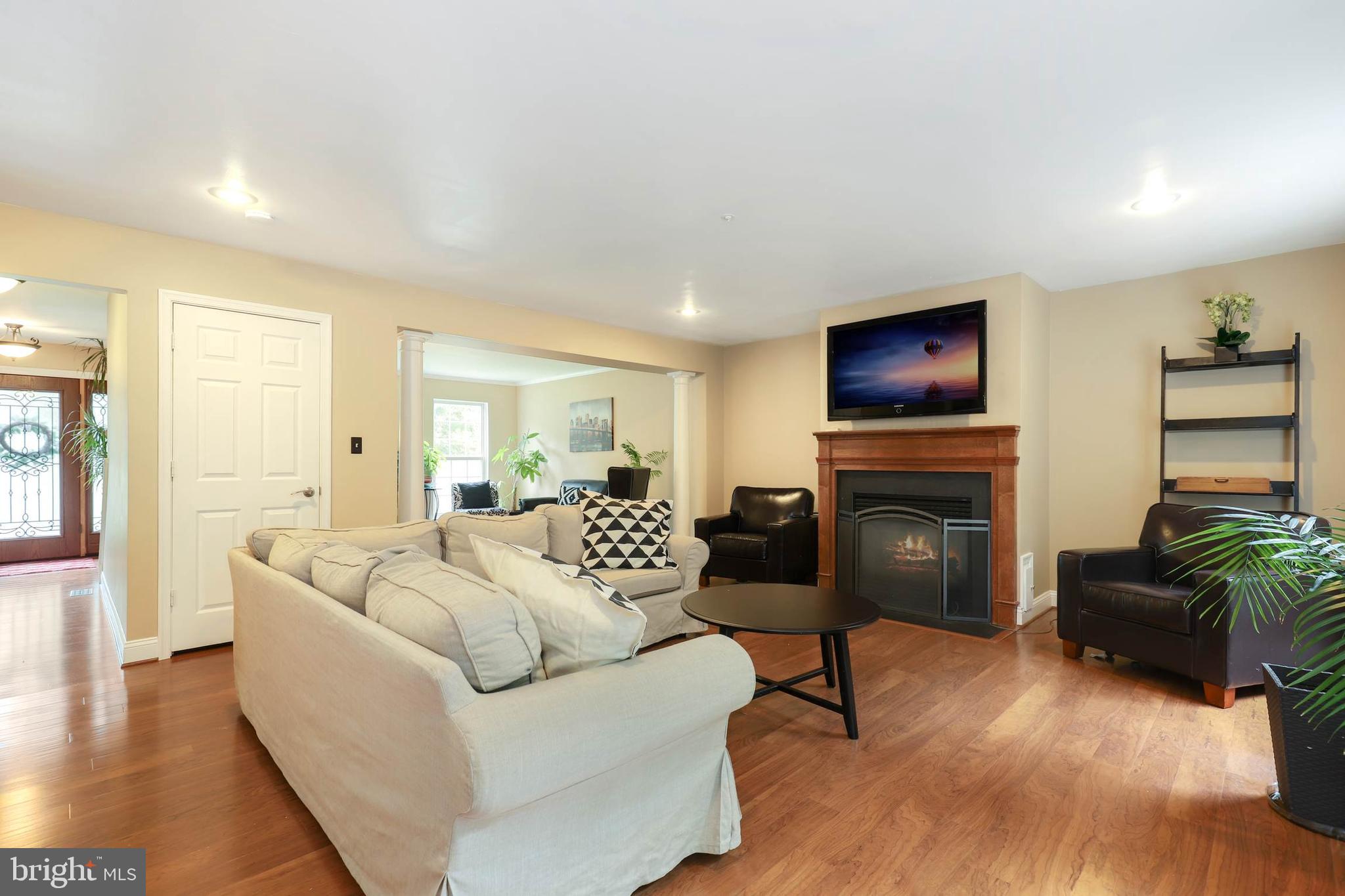 9211 Sandy Creek Road Fort Washington, MD 20744 - Photo 8 of 30 a living room with furniture a flat screen tv and a fireplace