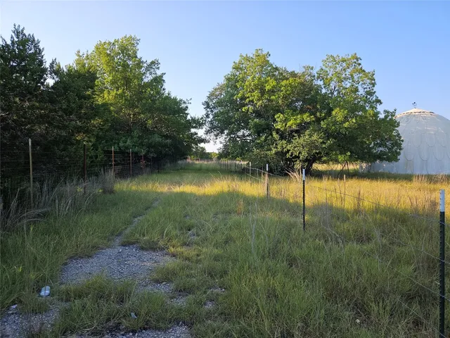 a view of a lake with a yard and large trees