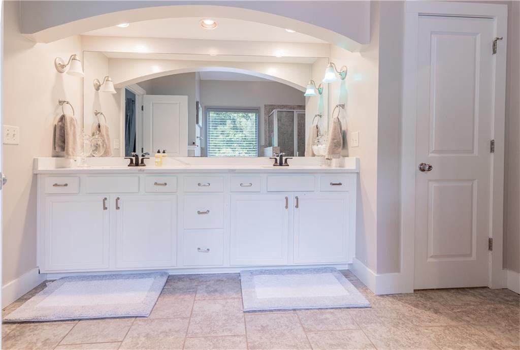 1567 Maplecliff Way Sugar Hill, GA 30518 - Photo 21 of 31 a bathroom with a sink a mirror and a vanity