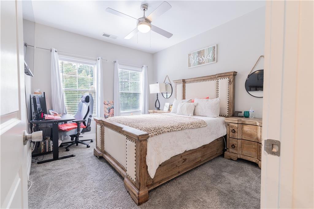 1567 Maplecliff Way Sugar Hill, GA 30518 - Photo 24 of 31 a spacious bedroom with a bed a table and large windows