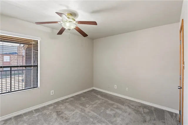 a view of a room with a ceiling fan and window