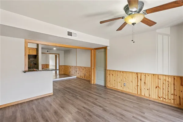 a view of an empty room with window and wooden floor