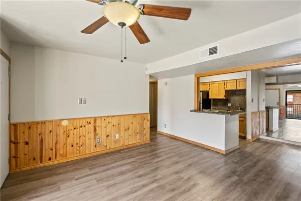 a view of an empty room with wooden floor