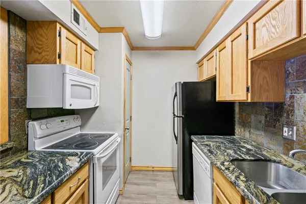 a kitchen with stainless steel appliances granite countertop a stove a refrigerator and a microwave