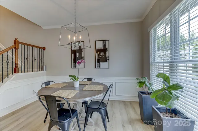 a dining room with furniture potted plants and wooden floor