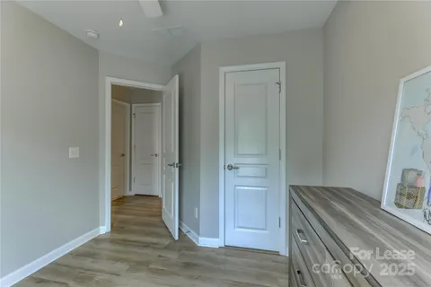 a view of a hallway with wooden floor and closet