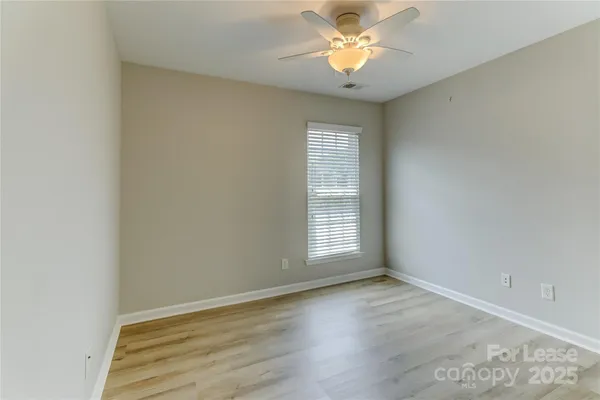 an empty room with wooden floor and window