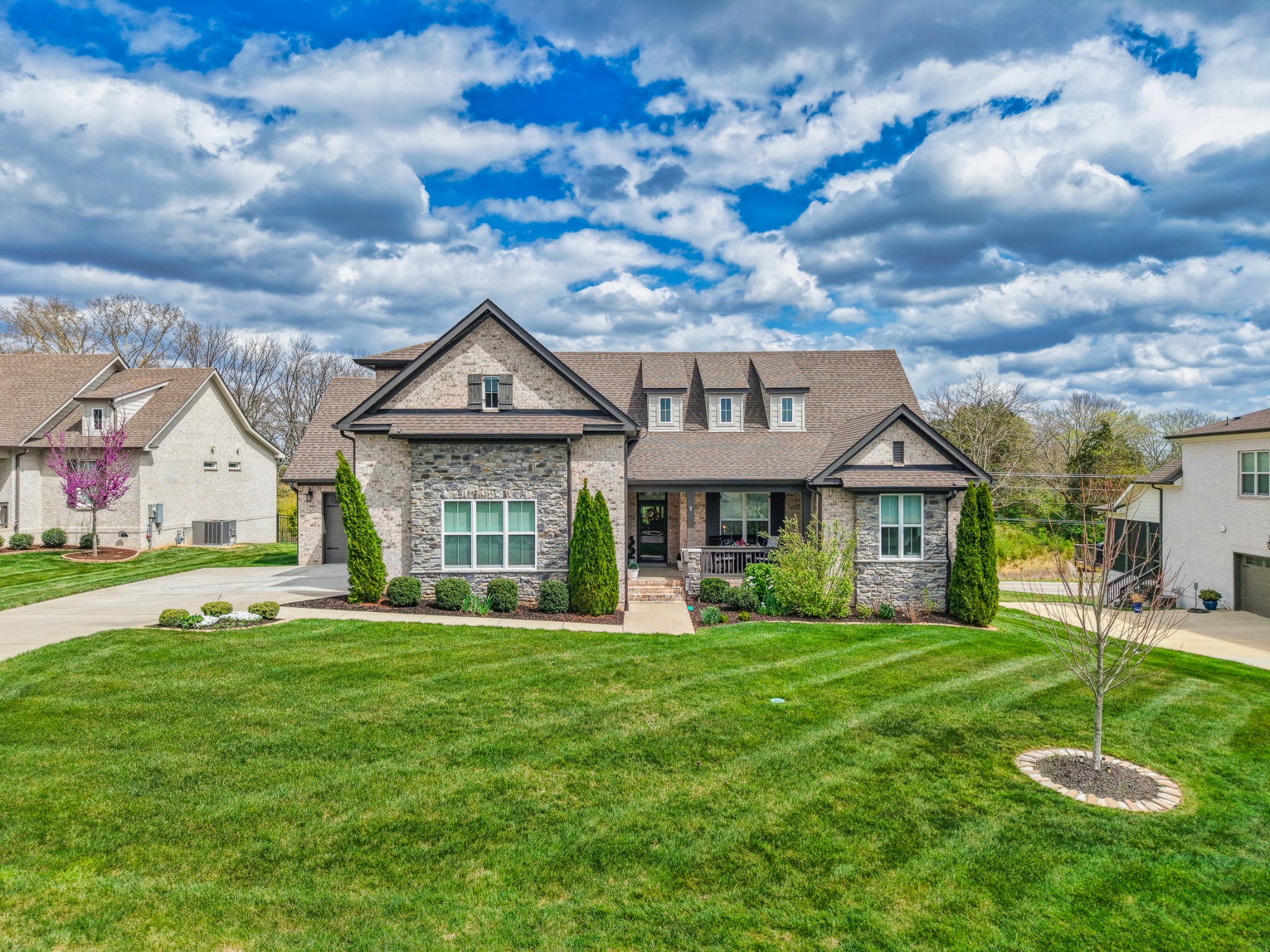 a front view of a house with yard and green space