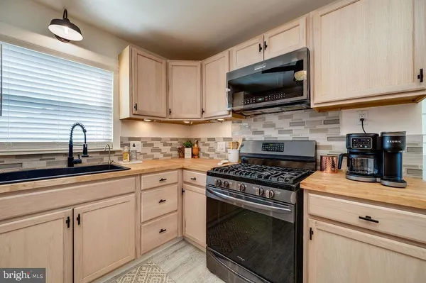 a kitchen with cabinets stainless steel appliances and a sink