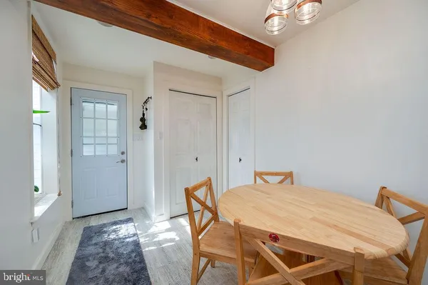 a kitchen with granite countertop a refrigerator oven a sink dishwasher and white cabinets with wooden floor