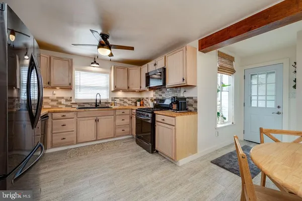 a kitchen with a table chairs sink and cabinets