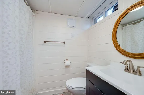 a bathroom with a sink a toilet and a window