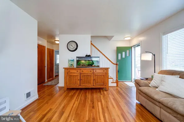 a living room with a couch and dresser with wooden floor