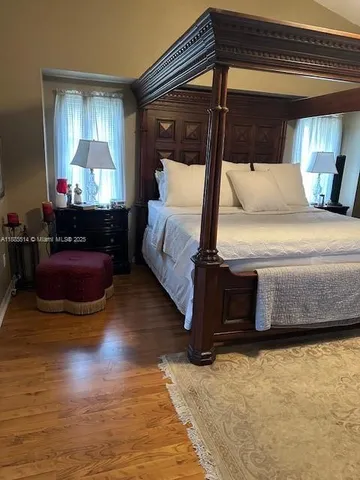 a bedroom with a bed and a flat tv screen on dresser