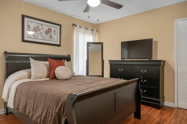a bedroom with a bed and a flat tv screen on dresser