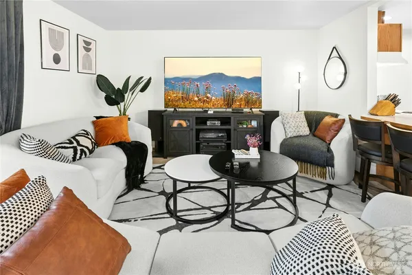 a living room with furniture a rug and a floor to ceiling window