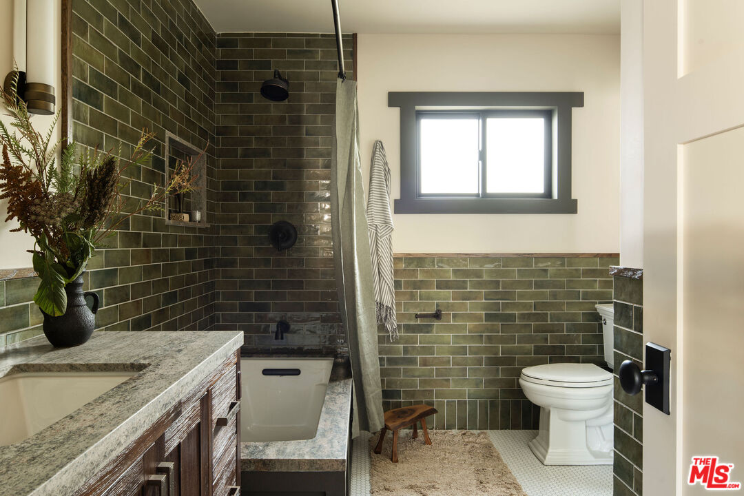 274 Acacia Street Altadena, CA 91001 - Photo 8 of 18 a bathroom with a granite countertop toilet a sink and mirror