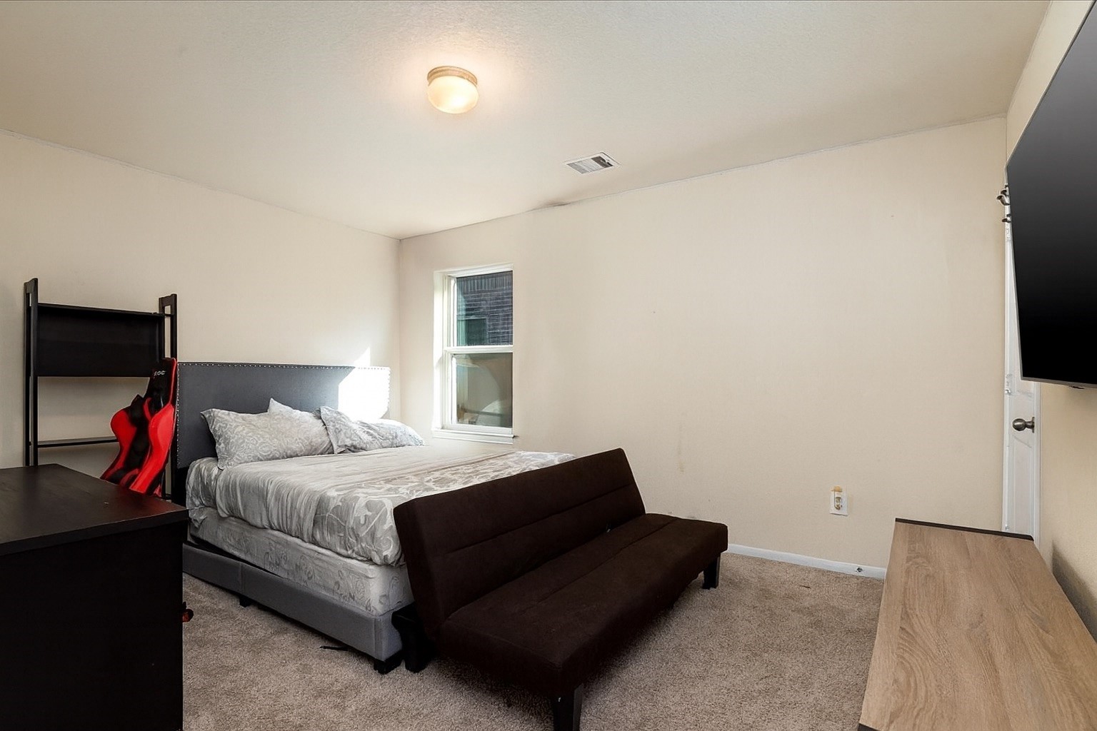 4606 Clara Rose Lane Katy, TX 77449 - Photo 17 of 25 a bedroom with a bed and a flat tv screen on a dresser