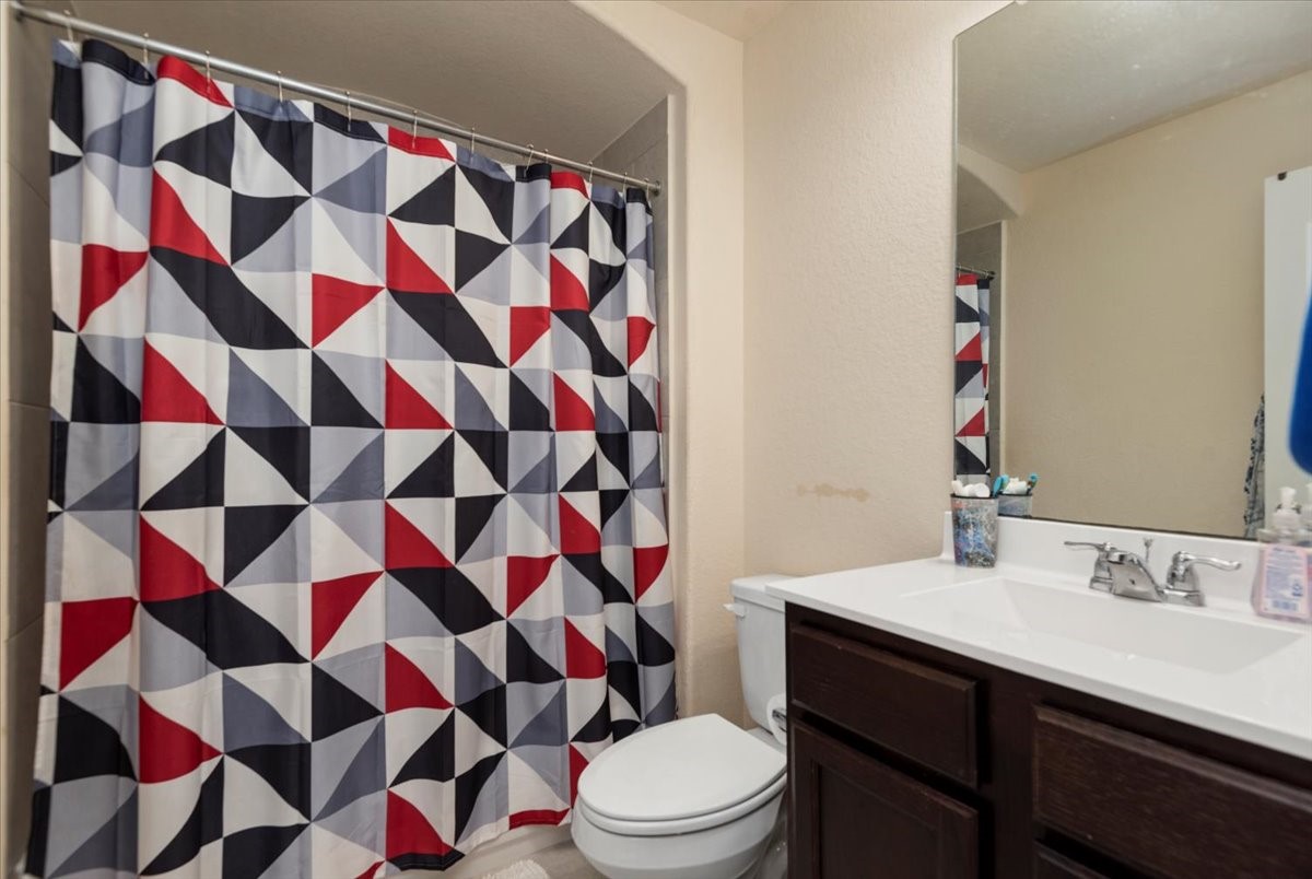 4606 Clara Rose Lane Katy, TX 77449 - Photo 20 of 25 a bathroom with a sink a toilet and shower curtain