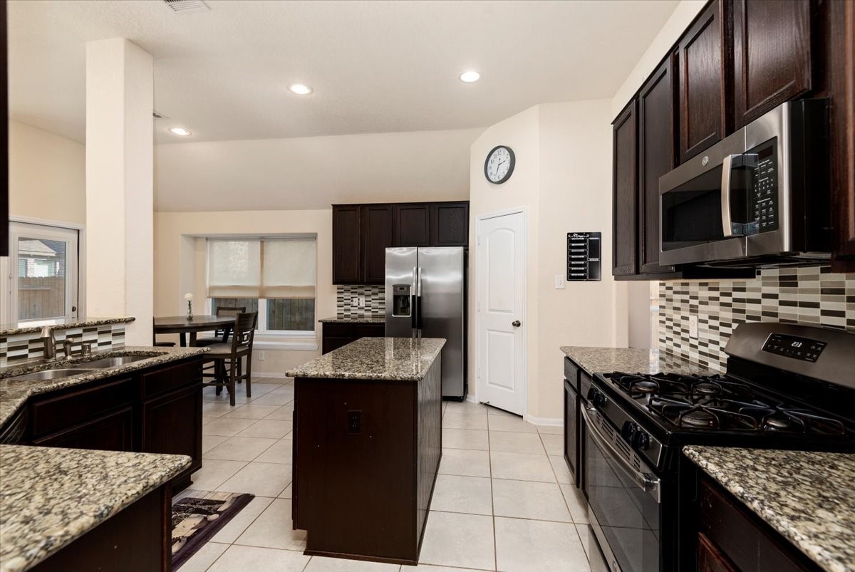 4606 Clara Rose Lane Katy, TX 77449 - Photo 6 of 25 a kitchen with stainless steel appliances granite countertop a stove top oven a sink dishwasher and a refrigerator
