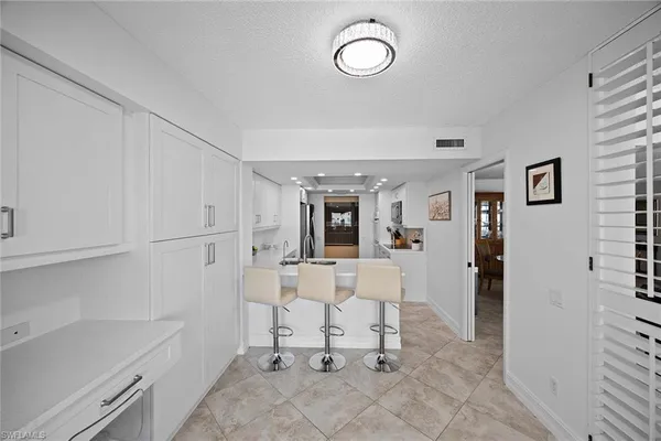 a view of kitchen with white cabinets and wooden floor