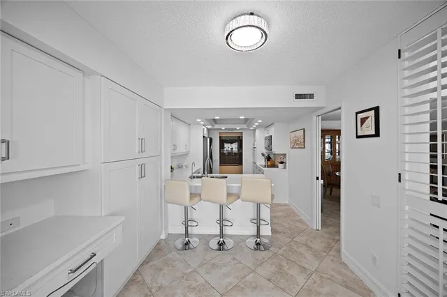 a view of kitchen with white cabinets and wooden floor