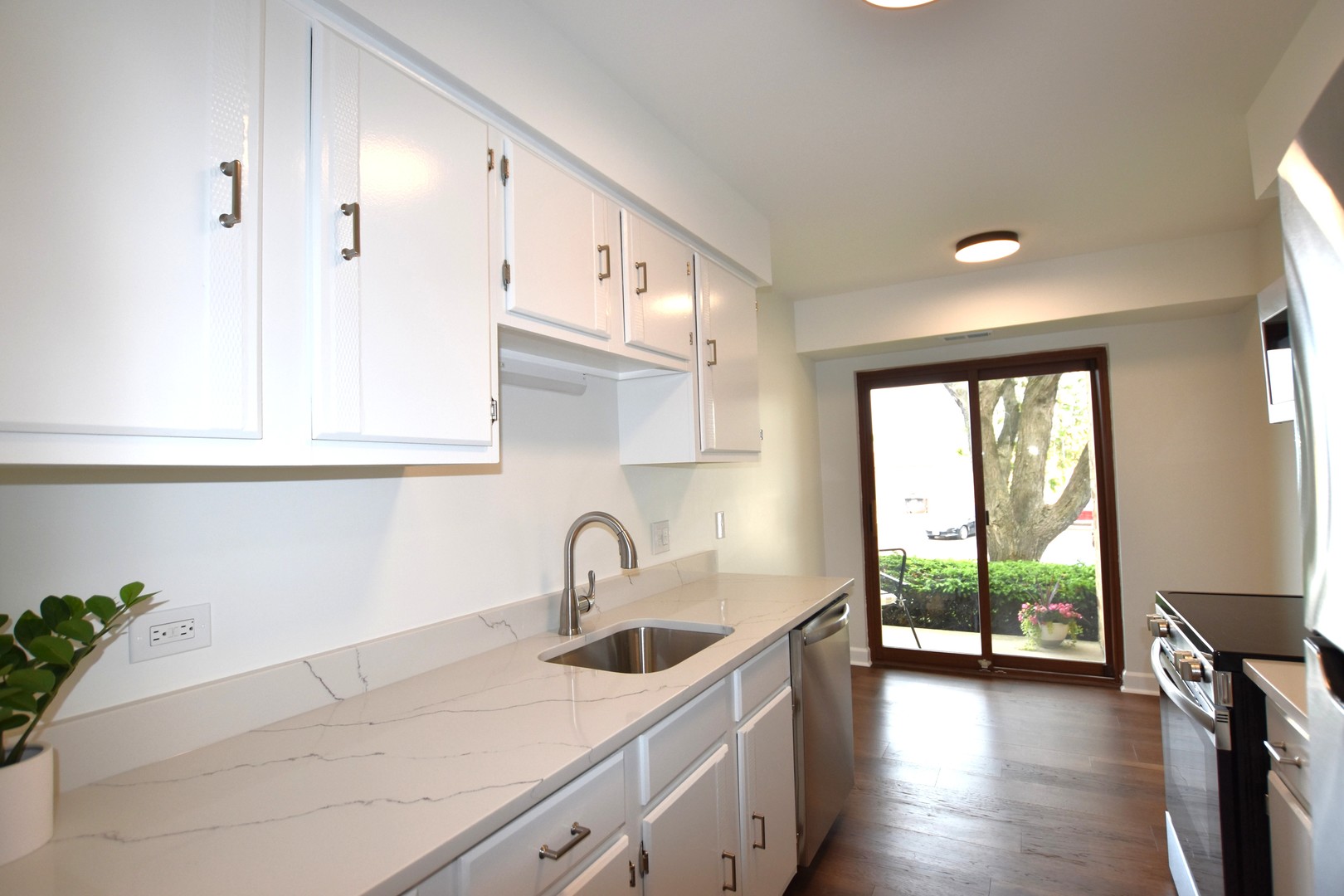 500 West Huntington Commons Road, Unit 157 Mount Prospect, IL 60056 - Photo 12 of 24 a kitchen with stainless steel appliances a sink a stove and a window