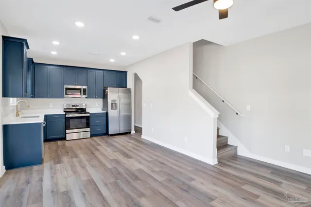 a kitchen with stainless steel appliances granite countertop a refrigerator and a stove top oven