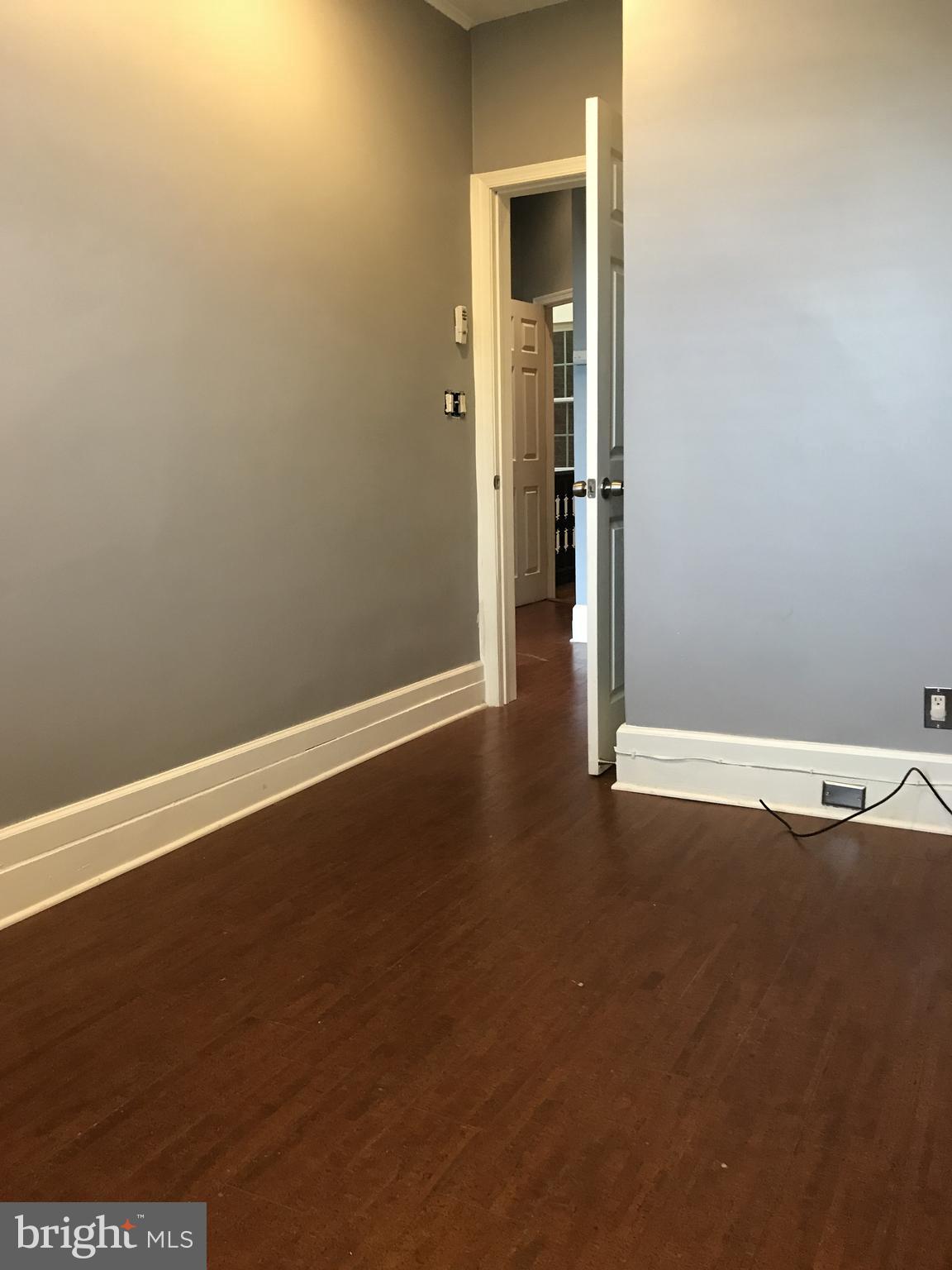 1609 Bolton Street Baltimore, MD 21217 - Photo 14 of 16 an empty room with wooden floor and windows
