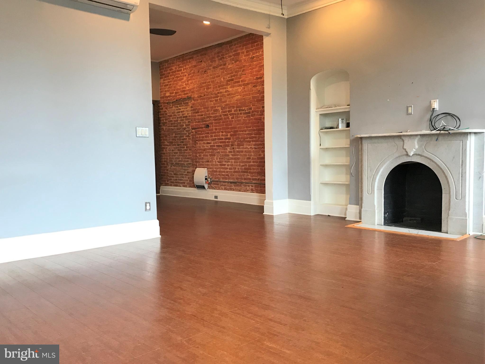 1609 Bolton Street Baltimore, MD 21217 - Photo 2 of 16 a view of empty room with fireplace and wooden floor