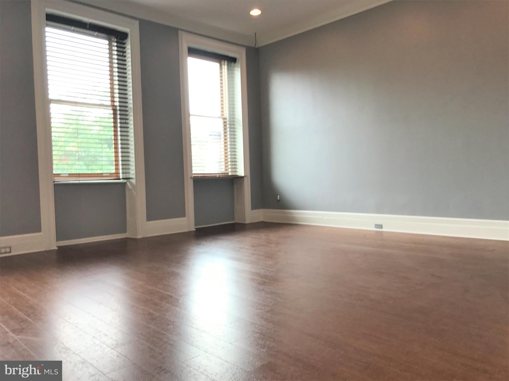 1609 Bolton Street Baltimore, MD 21217 - Photo 3 of 16 an empty room with wooden floor and windows