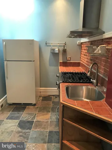 a kitchen with a refrigerator and a sink