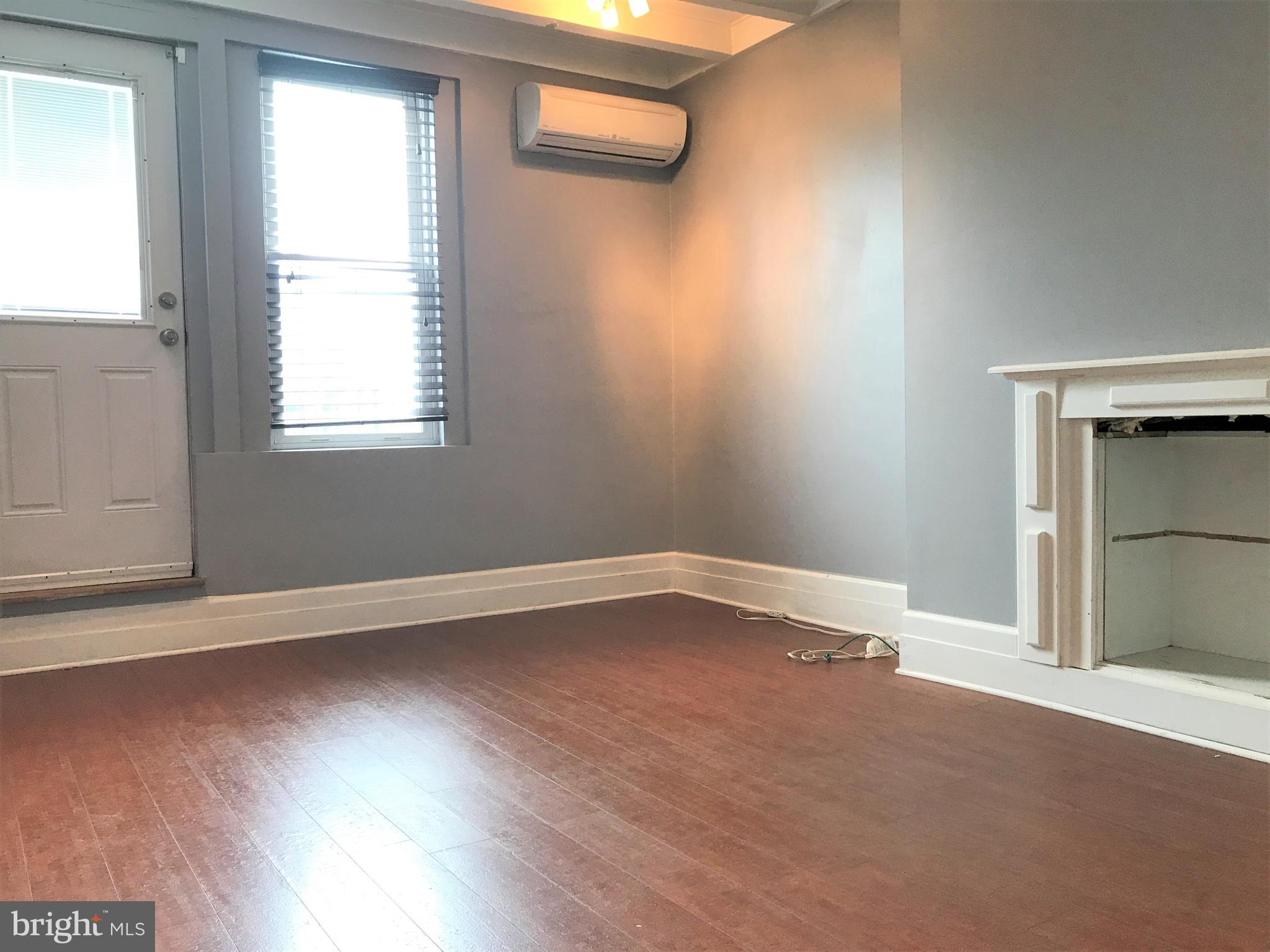 1609 Bolton Street Baltimore, MD 21217 - Photo 9 of 16 an empty room with wooden floor and windows